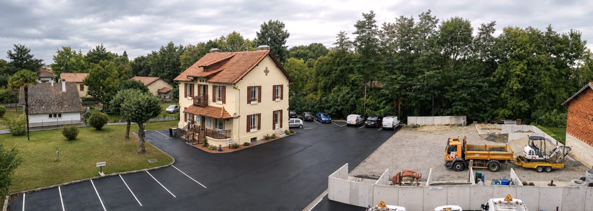 Les bureaux du syndicat, bâtiment à étage entouré de son parking et de son atelier.